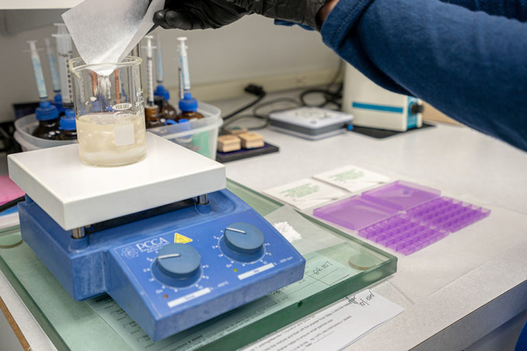 Compound Medication, Image of one of our pharmacists working on a drug compound order measuring with a beaker.
