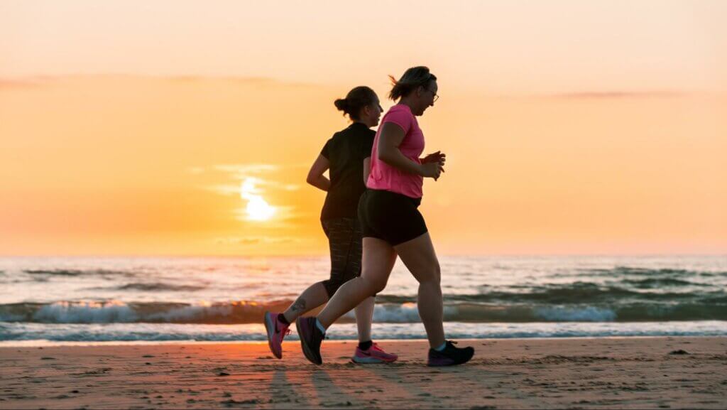 stress management, two girls are running at the sea shore